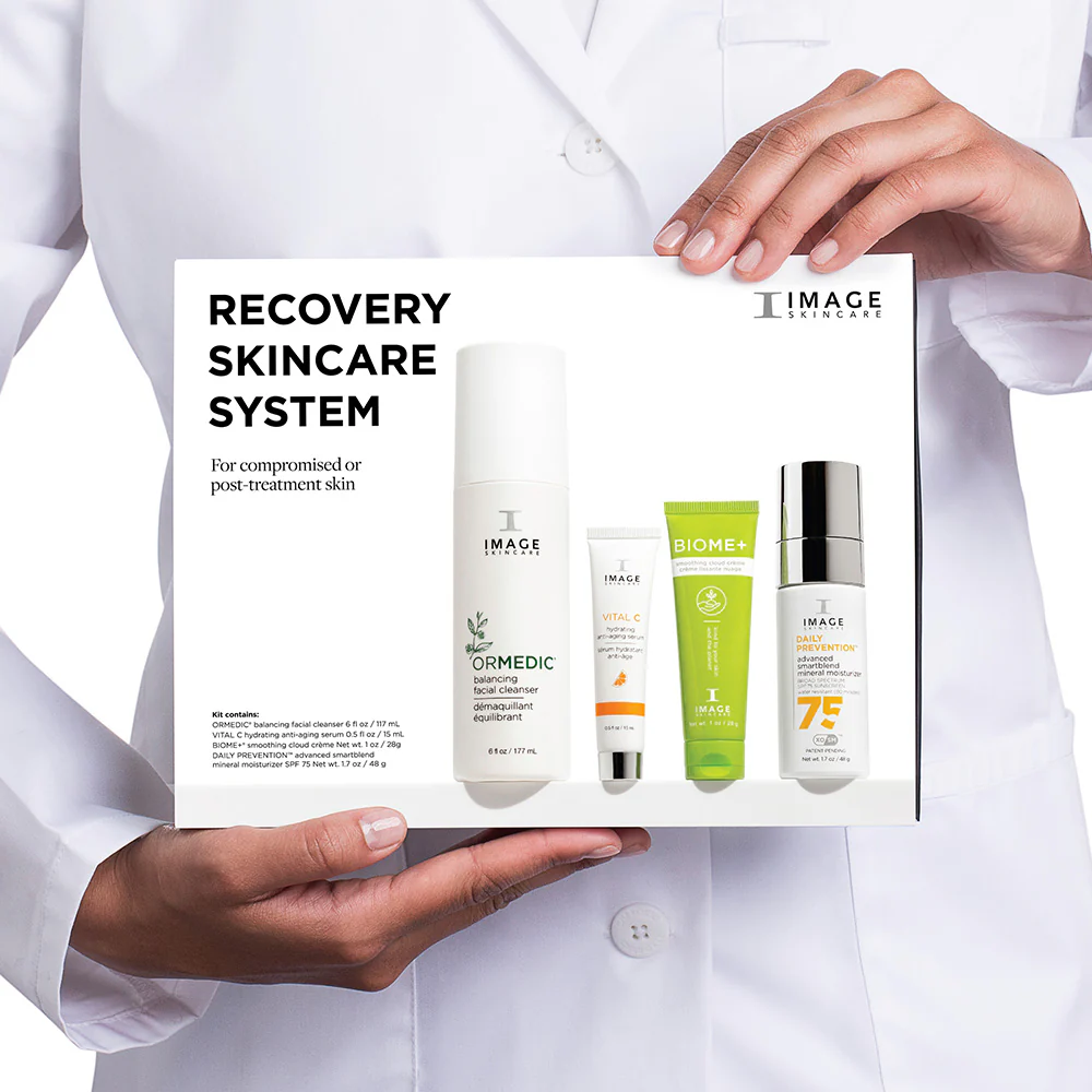 Image of a person holding the recovery skincare system products